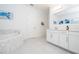 This serene bathroom features white cabinets and a tub with a mosaic surround, creating a spa-like retreat at 16054 Johns Lake Overlook Dr, Winter Garden, FL 34787