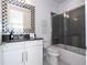The bathroom features a shower and tub combo with gray tile and a black and white checkered mirror at 16054 Johns Lake Overlook Dr, Winter Garden, FL 34787