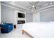 Cozy bedroom featuring modern fireplace, ceiling fan, and comfortable blue lounge chair at 16054 Johns Lake Overlook Dr, Winter Garden, FL 34787
