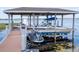 Covered boat lift with a motorboat and jet ski secured above the water at 16054 Johns Lake Overlook Dr, Winter Garden, FL 34787
