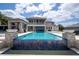 An impressive backyard with a pool, spa, outdoor kitchen, and a lake view backdrop at 16054 Johns Lake Overlook Dr, Winter Garden, FL 34787