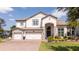 Charming two-story home with a well-manicured lawn, three-car garage, and beautiful stone accents at 16054 Johns Lake Overlook Dr, Winter Garden, FL 34787