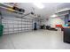 Spacious garage with epoxy flooring, overhead storage racks, and ample room for parking at 16054 Johns Lake Overlook Dr, Winter Garden, FL 34787