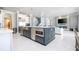 Modern kitchen island with seating and open concept layout to the dining and living areas at 16054 Johns Lake Overlook Dr, Winter Garden, FL 34787
