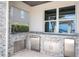 Well-equipped outdoor kitchen area featuring stainless steel appliances and granite countertops at 16054 Johns Lake Overlook Dr, Winter Garden, FL 34787