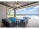 Covered patio with plush seating overlooking outdoor pool, hot tub, and waterfront views at 16054 Johns Lake Overlook Dr, Winter Garden, FL 34787