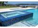 Beautiful pool with a multicolored tiled spa, perfect for entertaining and enjoying the lake view at 16054 Johns Lake Overlook Dr, Winter Garden, FL 34787