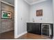 This wet bar area has a wine fridge, dark wood cabinets, and a framed billiard art at 16054 Johns Lake Overlook Dr, Winter Garden, FL 34787