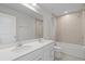 Bright bathroom featuring double sinks, white vanity, and shower-tub combo at 1616 Eucalyptus Way, Davenport, FL 33837