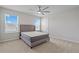 Bright bedroom with sunny windows, neutral carpet, and a modern ceiling fan at 1616 Eucalyptus Way, Davenport, FL 33837