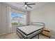 Cozy bedroom with a metal frame bed, a light wood nightstand, and a bright window at 1616 Eucalyptus Way, Davenport, FL 33837