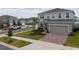 Two-story home features well-manicured lawn, landscaping, and a two-car garage on a corner lot at 1616 Eucalyptus Way, Davenport, FL 33837