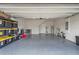 Spacious garage with epoxy flooring, storage shelves, and ample room for parking and storage at 1616 Eucalyptus Way, Davenport, FL 33837