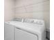 Laundry room featuring full-size washing machine, dryer, and overhead shelving at 1616 Eucalyptus Way, Davenport, FL 33837