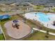 An aerial shot of the community playground and pool, complemented by lush greenery and surrounding neighborhood streets at 1616 Eucalyptus Way, Davenport, FL 33837