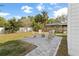 Lush backyard featuring a stone patio with comfortable seating, mature trees, and lush green grass at 1667 Spring Loop Way, Winter Garden, FL 34787