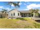 A well maintained backyard with covered patio, seating area, and beautiful lush lawn at 1667 Spring Loop Way, Winter Garden, FL 34787