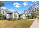 Charming home with white siding, stone accents, mature trees, and a well-manicured lawn at 1667 Spring Loop Way, Winter Garden, FL 34787