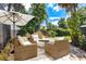 Outdoor seating area in backyard with an umbrella, green foliage, and a cozy fire pit at 169 Winding Oaks Ln, Oviedo, FL 32765