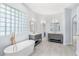Spacious bathroom featuring double vanities, a soaking tub, and glass block window at 169 Winding Oaks Ln, Oviedo, FL 32765