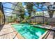 A screened-in pool featuring a hot tub, waterfall, and adjacent outdoor grilling area enhances backyard living at 169 Winding Oaks Ln, Oviedo, FL 32765