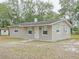 Modest single-story home with neutral paint, simple landscaping, and mature trees in the front yard at 1708 Nebraska Ave, Kissimmee, FL 34744