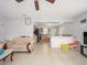 Open-concept living room showcasing tile flooring, a ceiling fan, and seamless transition to the kitchen at 1708 Nebraska Ave, Kissimmee, FL 34744