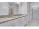Bathroom featuring dual sinks, granite countertops, white cabinets, and shower at 1855 Flora Pass Pl, Kissimmee, FL 34747