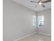 Bright bedroom with tile floors, neutral walls, ceiling fan, and two large windows at 1855 Flora Pass Pl, Kissimmee, FL 34747
