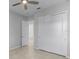 This bedroom features a ceiling fan, tile floors, closet and entryway to the bathroom at 1855 Flora Pass Pl, Kissimmee, FL 34747