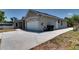 Exterior showcasing the home's side and driveway, complete with trash receptacles and side-entry door at 2300 Dawnwood Ln, Orlando, FL 32809
