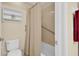 Bathroom with toilet, shelving, tiled shower, and safety bars at 23520 San Sebastian Ct, Sorrento, FL 32776