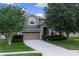 Charming two-story home with a well-manicured lawn and attached two-car garage at 23520 San Sebastian Ct, Sorrento, FL 32776