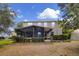 View of the rear of the home, with a large screened-in patio and landscaped yard at 23520 San Sebastian Ct, Sorrento, FL 32776