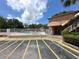 A community pool is fenced off with parking spaces in the foreground of a brick building on a bright day at 2426 Branch Way # 200, Maitland, FL 32751