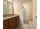 Bathroom featuring granite countertops, a large mirror, and a walk in shower at 2612 Shantiniketan Blvd # G12, Tavares, FL 32778