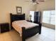 Cozy bedroom with a dark wood frame, windows, and tile flooring for low maintenance at 2612 Shantiniketan Blvd # G12, Tavares, FL 32778