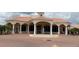An elegant clubhouse with a fountain, grand entrance, and palm trees enhancing the curb appeal at 2612 Shantiniketan Blvd # G12, Tavares, FL 32778