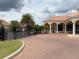 The community's gated entrance showcases a clubhouse, lush landscaping, and brick-paved drive for a secure and welcoming feel at 2612 Shantiniketan Blvd # G12, Tavares, FL 32778