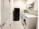 Convenient laundry room equipped with a washer, dryer, and shelving for storage at 2612 Shantiniketan Blvd # G12, Tavares, FL 32778