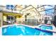 Outdoor pool area with hot tub and safety fence surrounded by a screened enclosure at 2791 Punctuation Pl, Kissimmee, FL 34746