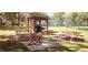 Community picnic area with wooden tables, benches, and a built-in grill at 2810 N Powers Dr # 59, Orlando, FL 32818