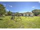 The spacious backyard includes a swing set, play area, lush green grass, screened-in patio, and well-maintained landscaping at 2850 Babylon Ct, Oviedo, FL 32765