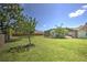 Lush backyard features a screened-in pool area, green lawn, mature trees, and beautiful landscaping at 2850 Babylon Ct, Oviedo, FL 32765