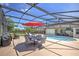 Screened in backyard and pool with an umbrella, outdoor furniture, and a barbecue at 2850 Babylon Ct, Oviedo, FL 32765