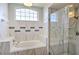 Modern bathroom featuring a soaking tub and separate glass enclosed shower with beautiful marble patterned tile at 2850 Babylon Ct, Oviedo, FL 32765