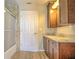 Bathroom with granite countertops, wood cabinets, and a shower and tub with a sliding glass door at 2850 Babylon Ct, Oviedo, FL 32765