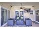 Cozy covered patio with comfortable seating, ceiling fan, TV, and a sliding glass door view of the backyard at 2850 Babylon Ct, Oviedo, FL 32765