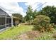 View of backyard that features a mix of green grass, trees, plants, and partially-screened in pool at 2900 Cullen Lake Shore Dr, Belle Isle, FL 32812