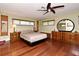 Relaxing bedroom with hardwood floors, natural light, and a ceiling fan for added comfort at 2900 Cullen Lake Shore Dr, Belle Isle, FL 32812